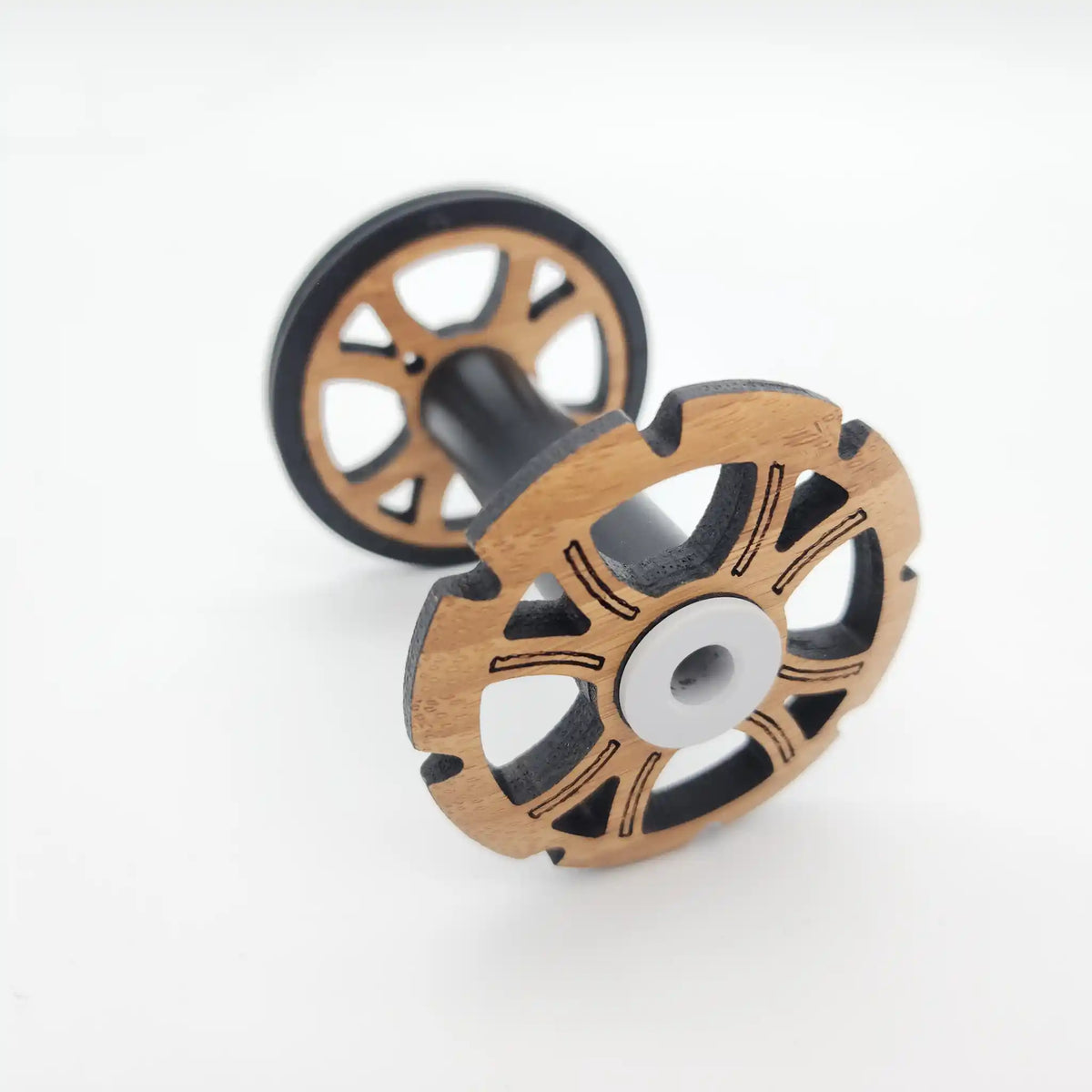 Majacraft Stylus bobbin at an angle, notched bamboo flange with black fibreglass barrel and white nylon bearing