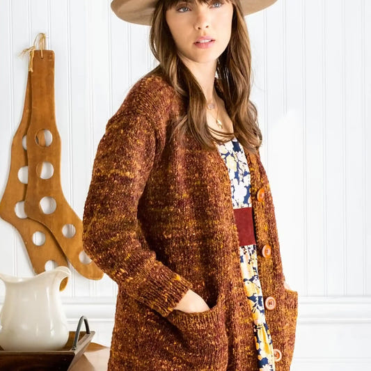 Woman wearing brown cardigan and hat, norothing1