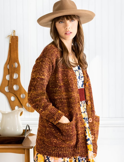 Woman wearing brown cardigan and hat, norothing1
