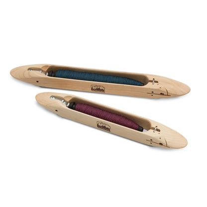 Schacht 12 inch and 15 inch end delivery shuttles side by side, each loaded with a wound pirn