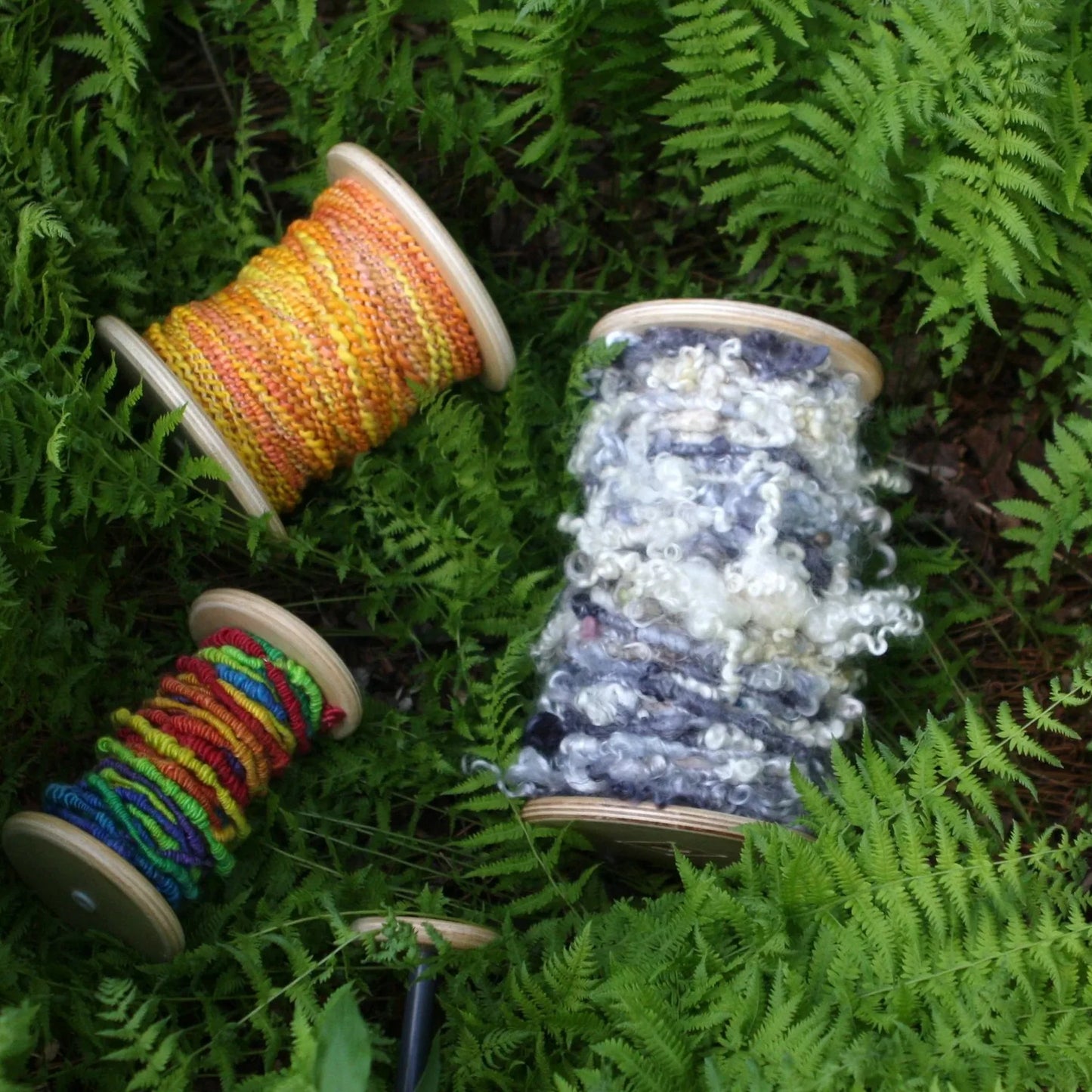 SpinOlution bobbins shown with yarn wound on