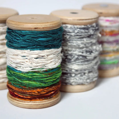 Four SpinOlution Baltic birch bobbins shown from both ends