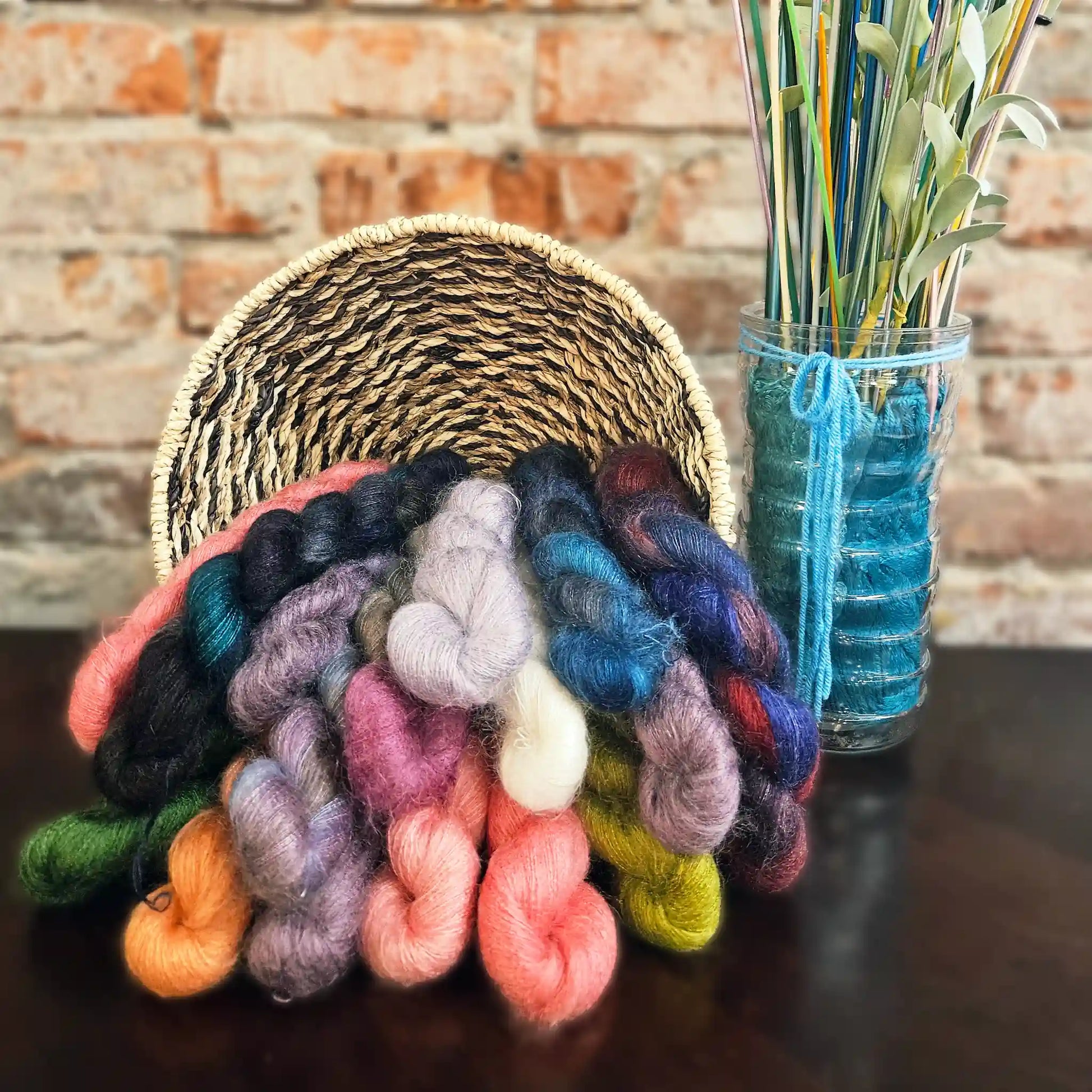 Urth Yarns Bonmoher yarn shown in a basket with all the colors falling out in an arrangement