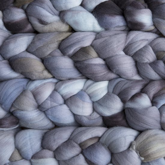 Color 043 Plomo. A handyed merino top with shades of charcoal, seal blue, sky blue, and peppermint blue..