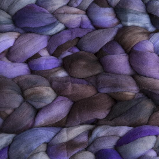 Color 066 Lavanda. A handyed merino top with shades of violet, lavender, storm blue, chocolate brown, and sky blue.
