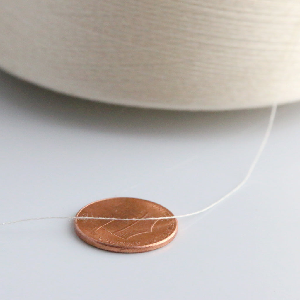 Close up view of 140/2 silk thread (with penny for scale)