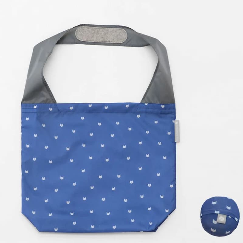 Flip & Tumble tote style bag laid flat. Bag is blue colored with small cat head printed pattern.