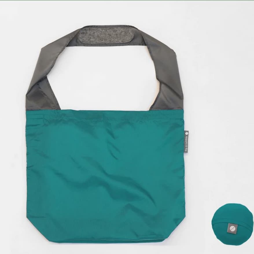 Flip & Tumble tote style bag laid flat. Bag is peacock colored with grey shoulder strap.