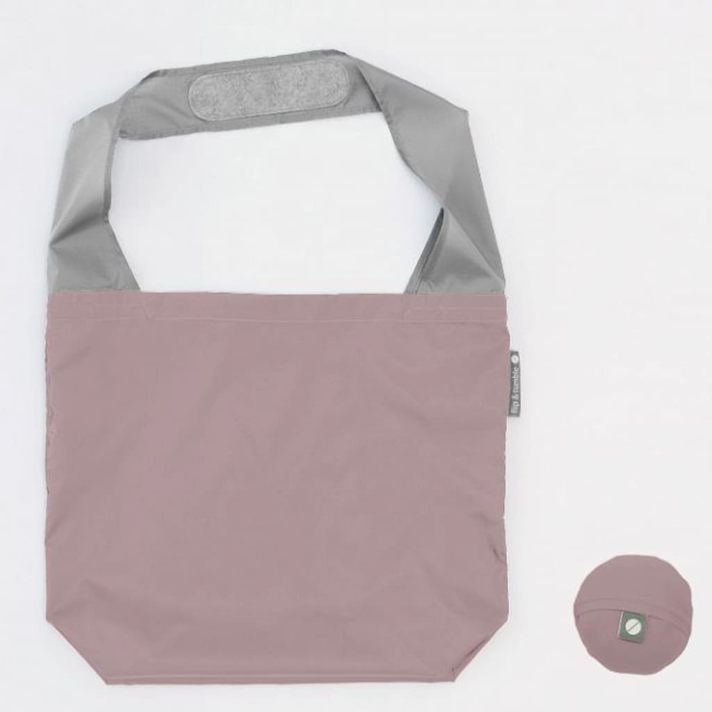 Flip & Tumble tote style bag laid flat. Bag is dusty pink colored with a grey shoulder strap. 