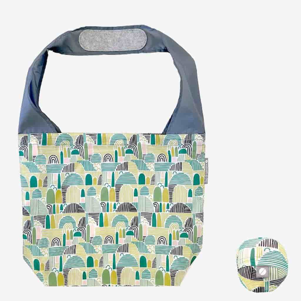 Flip & Tumble tote style bag laid Flat with shades of green in a field pattern.