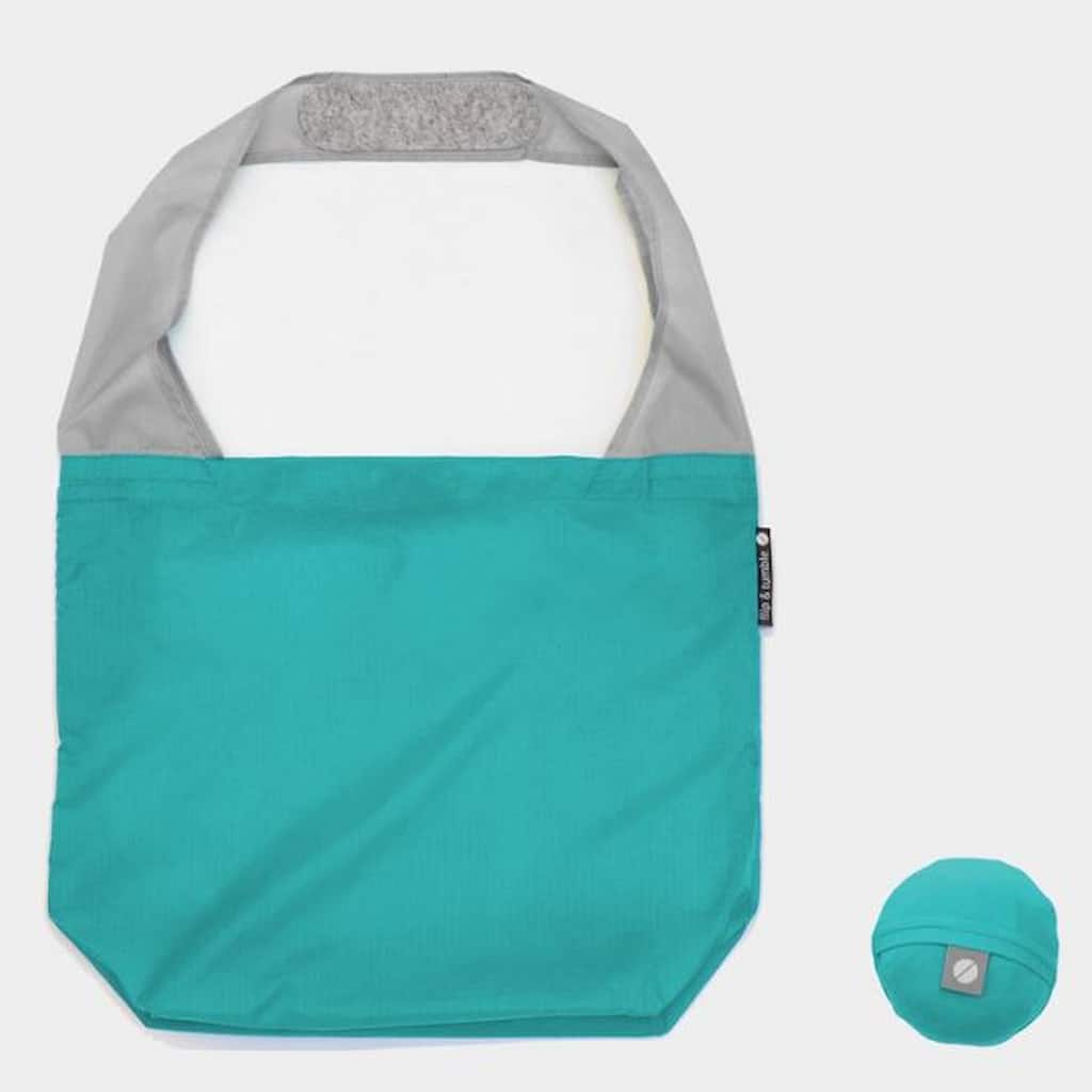 Flip & Tumble tote style bag laid flat. Bag is teal colored with grey shoulder strap.