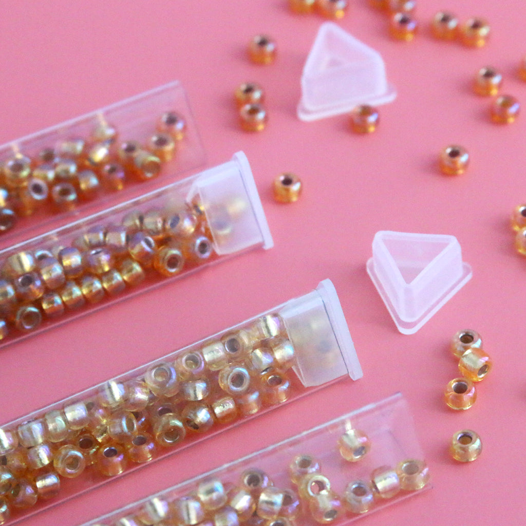 Miyuki seed beads size 6/0 in a triangular holding tube.