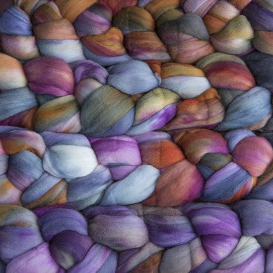 Color 862 Piedras. A handyed merino top with shades of violet, leaf green, amber, sky blue, sienna, and fuschia.
