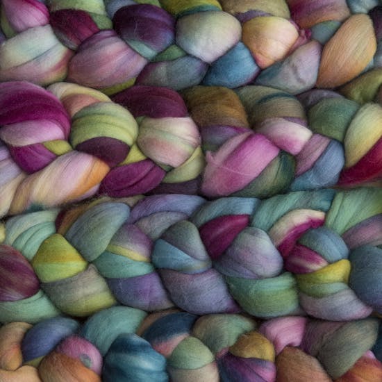 Color 866 Arco Iris. A handyed merino top with shades of magenta, pink, chartruese, light cyan, and sienna.