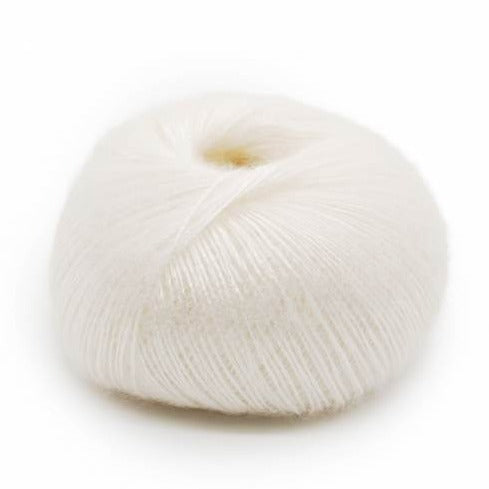 Wound ball of Mirasol Inka yarn in a slightly shiny white/pearl color.