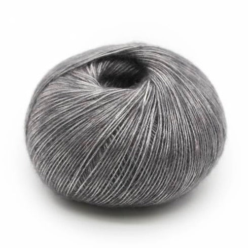 Wound ball of Mirasol Inka yarn in a slightly shiny platinum/grey color.