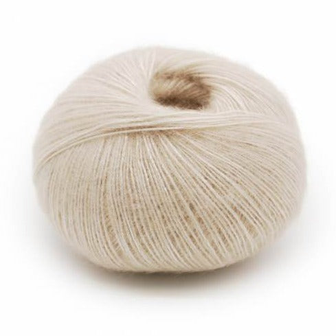 Wound ball of Mirasol Inka yarn in a slightly shiny smoky quartz/ cream color.
