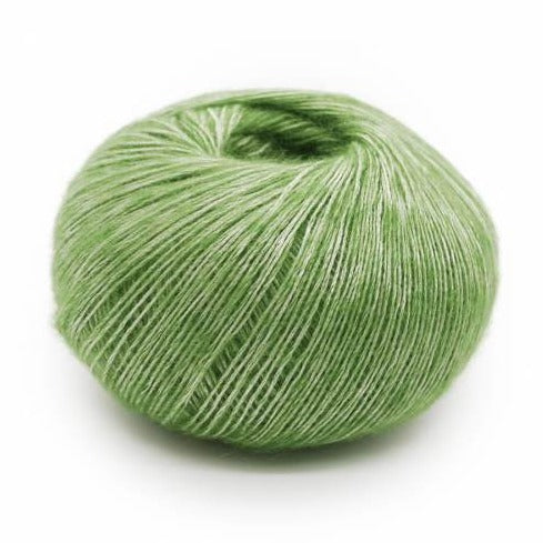 Wound ball of Mirasol Inka yarn in a slightly shiny peridot/green color.