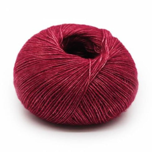 Wound ball of Mirasol Inka yarn in a slightly shiny garnet/red color.