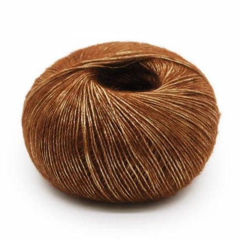 Wound ball of Mirasol Inka yarn in a slightly shiny topaz/brown color.