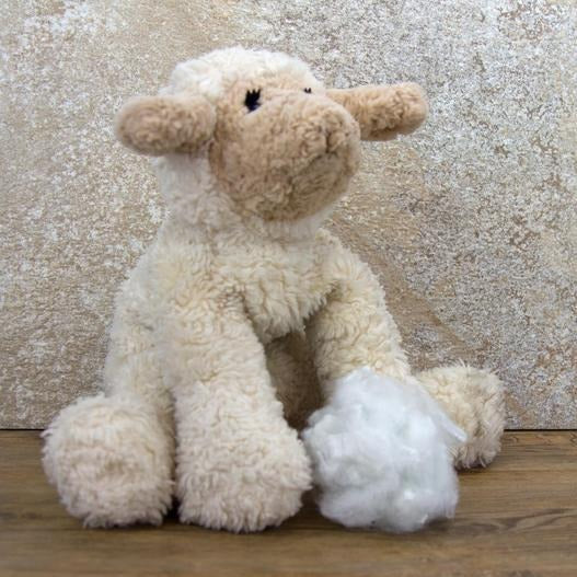 A handful of white Polyester Fiber Staples next to a sheep stuffed animal