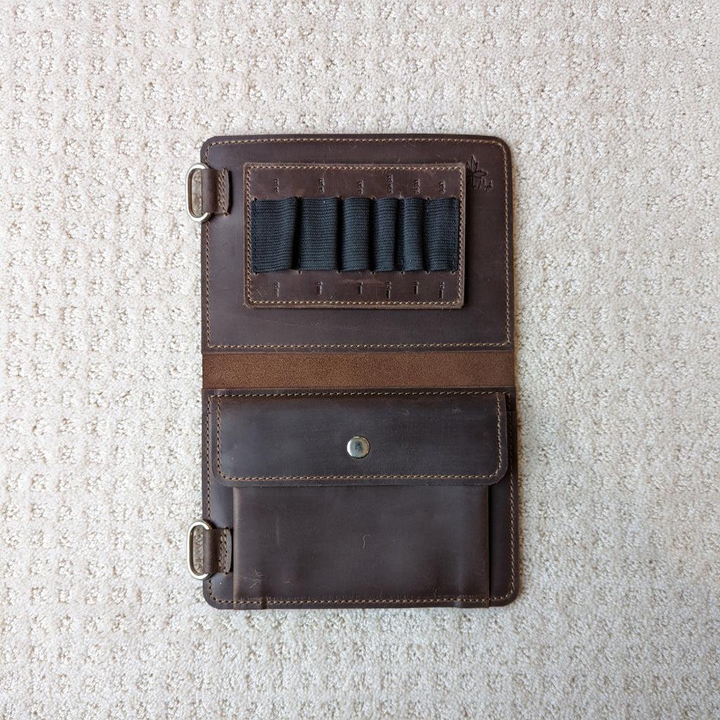 Chocolate colored leather knitting needle case open showing small slots and notions pocket 