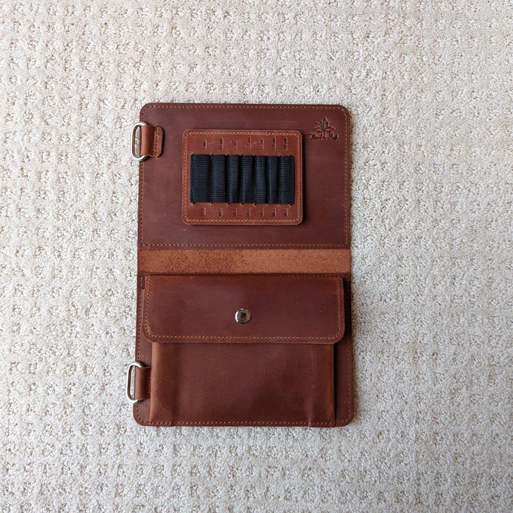 Whiskey colored leather knitting needle case open showing slots and notions pocket 