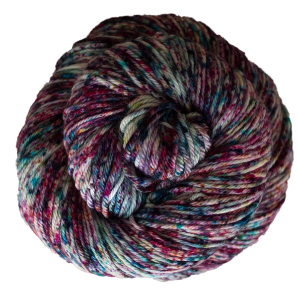A skein of Caprino in the color Cello 728, a speckled pink, purple, and blue colorway.