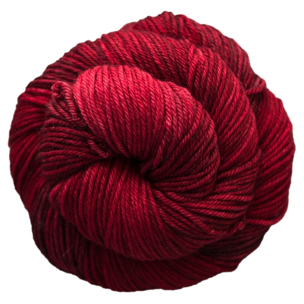 A skein of Caprino in the color Cereza 033, a tonal red colorway.