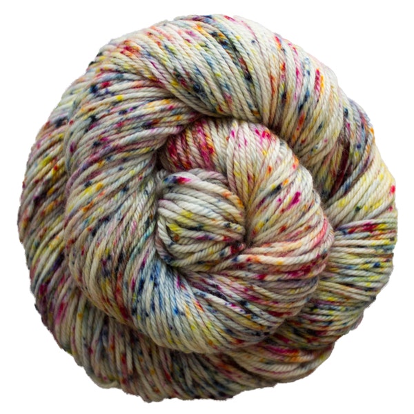 A skein of Caprino in the color Moon Trio Full 697, a white with rainbow speckles colorway.