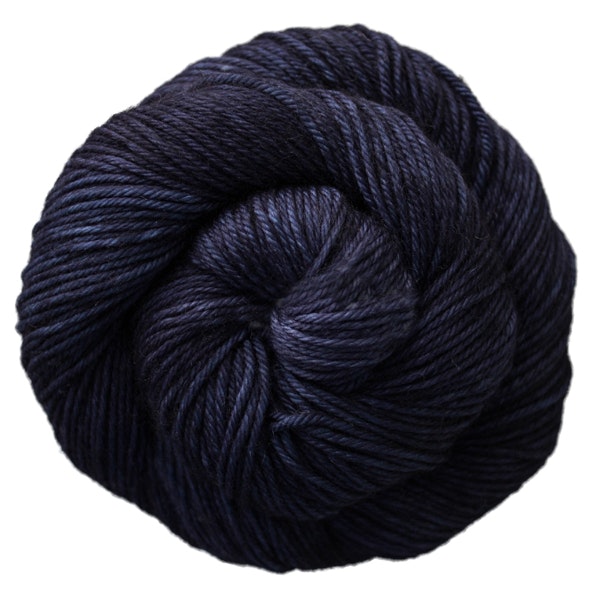 A skein of Caprino in the color Paris Night 052, a tonal navy blue colorway.