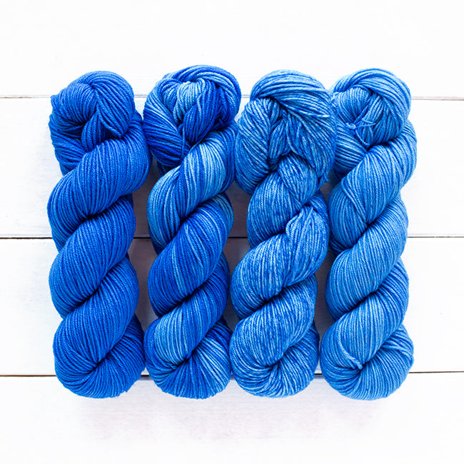 Color 805, a dark blue 4 skein gradient dyed yarn kit fading from dark solid to speckled.