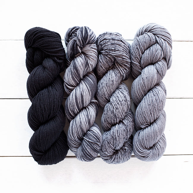 Color 806, a black 4 skein gradient dyed yarn kit fading from dark solid to speckled.