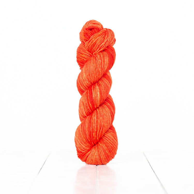 Color 6052, a variegated monochromatic skein of bright orange yarn.