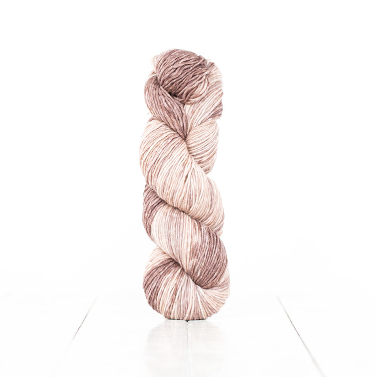 Color 6062, a variegated monochromatic skein of light brown yarn.
