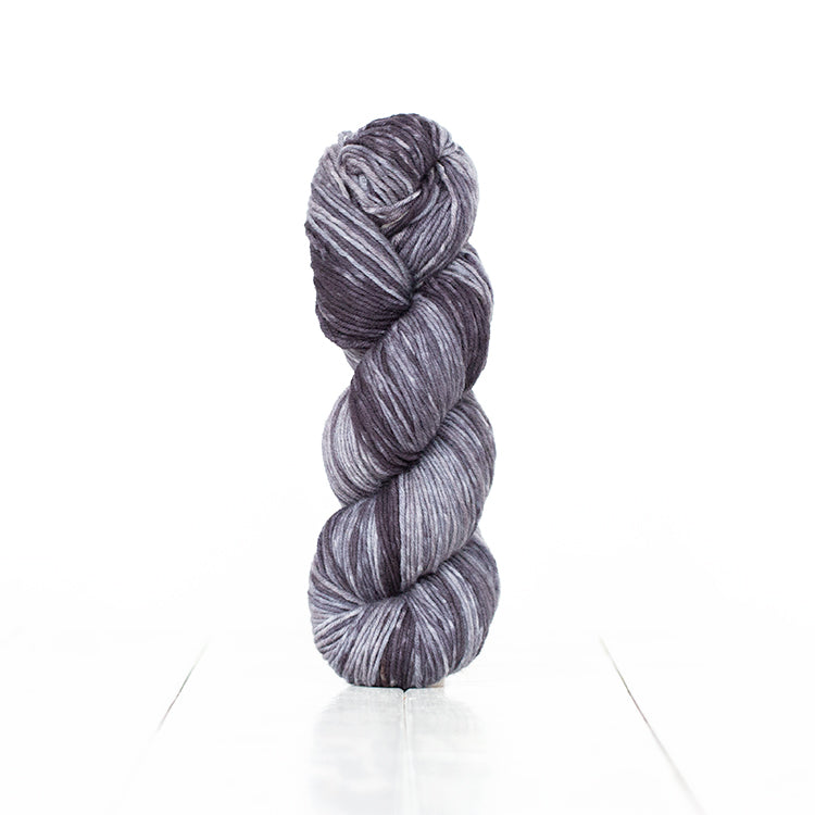 Color 6063, a variegated monochromatic skein of cool toned dark grey yarn.