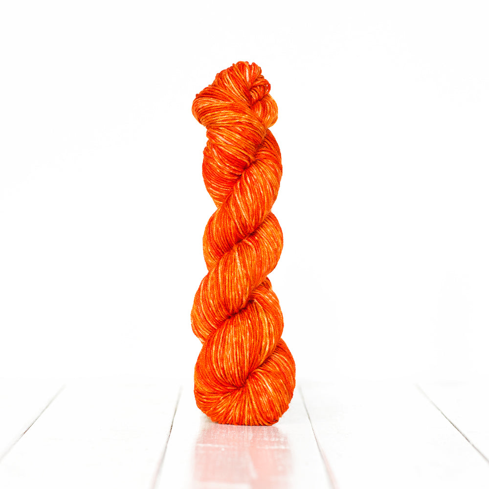 Color 3052, a variegated monochromatic skein of bright orange yarn.
