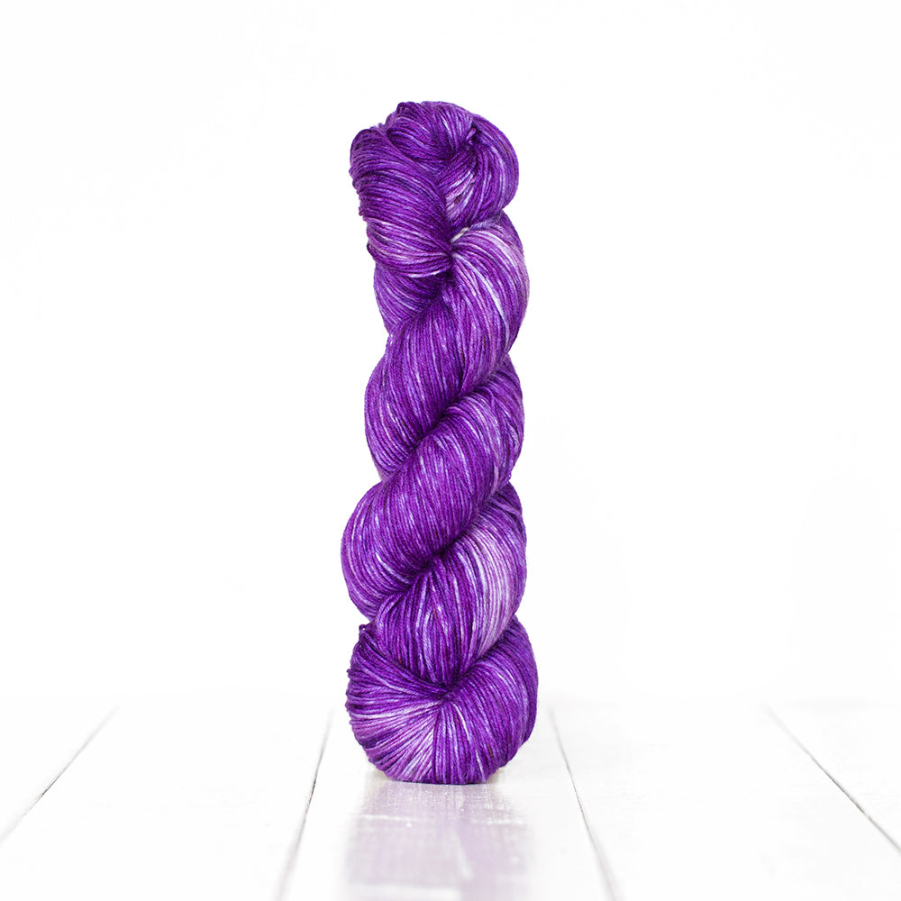 Color 3055, a variegated monochromatic skein of vibrant purple yarn.
