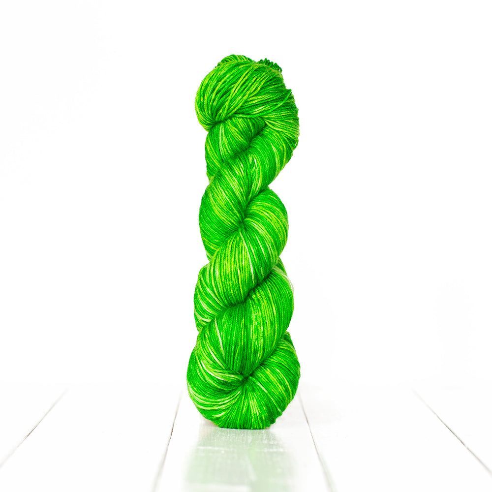 Color 3058, a variegated monochromatic skein of bright spring green yarn.