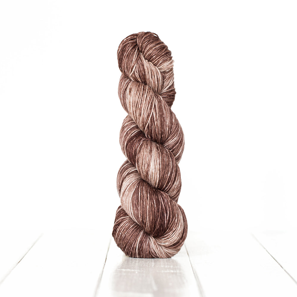 Color 3061, a variegated monochromatic skein of greyish brown yarn.