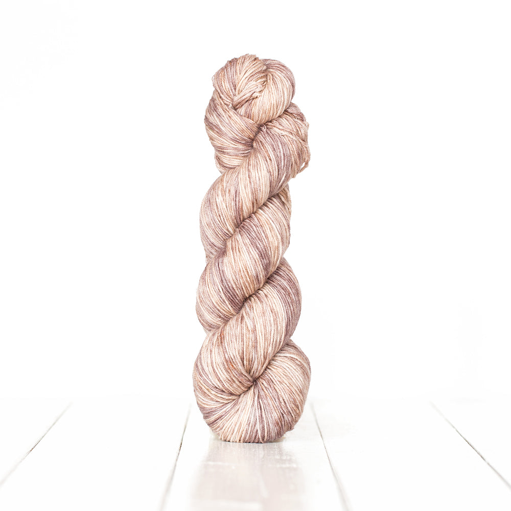 Color 3062, a variegated monochromatic skein of light brown yarn.