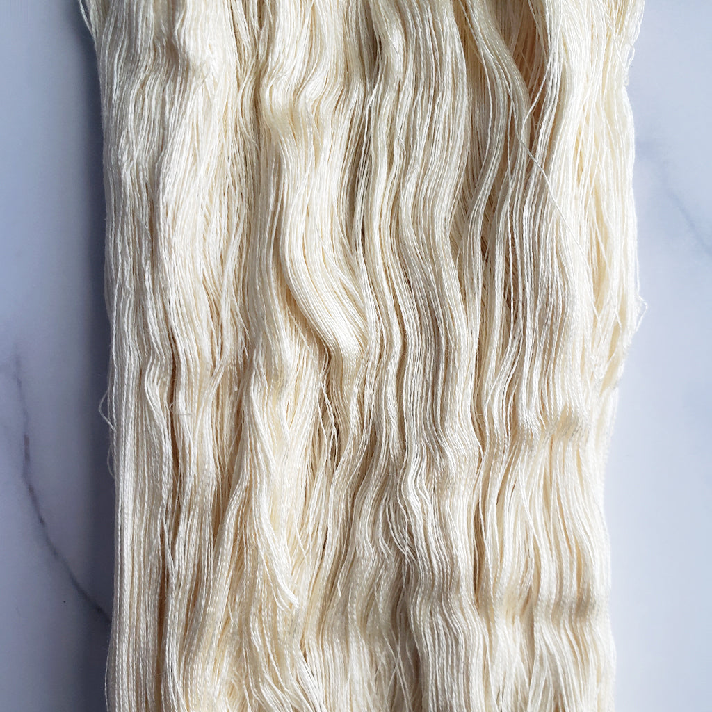 A close up picture of Paradise Fibers 140/2 Undyed Spun Silk Cobweb Yarn.