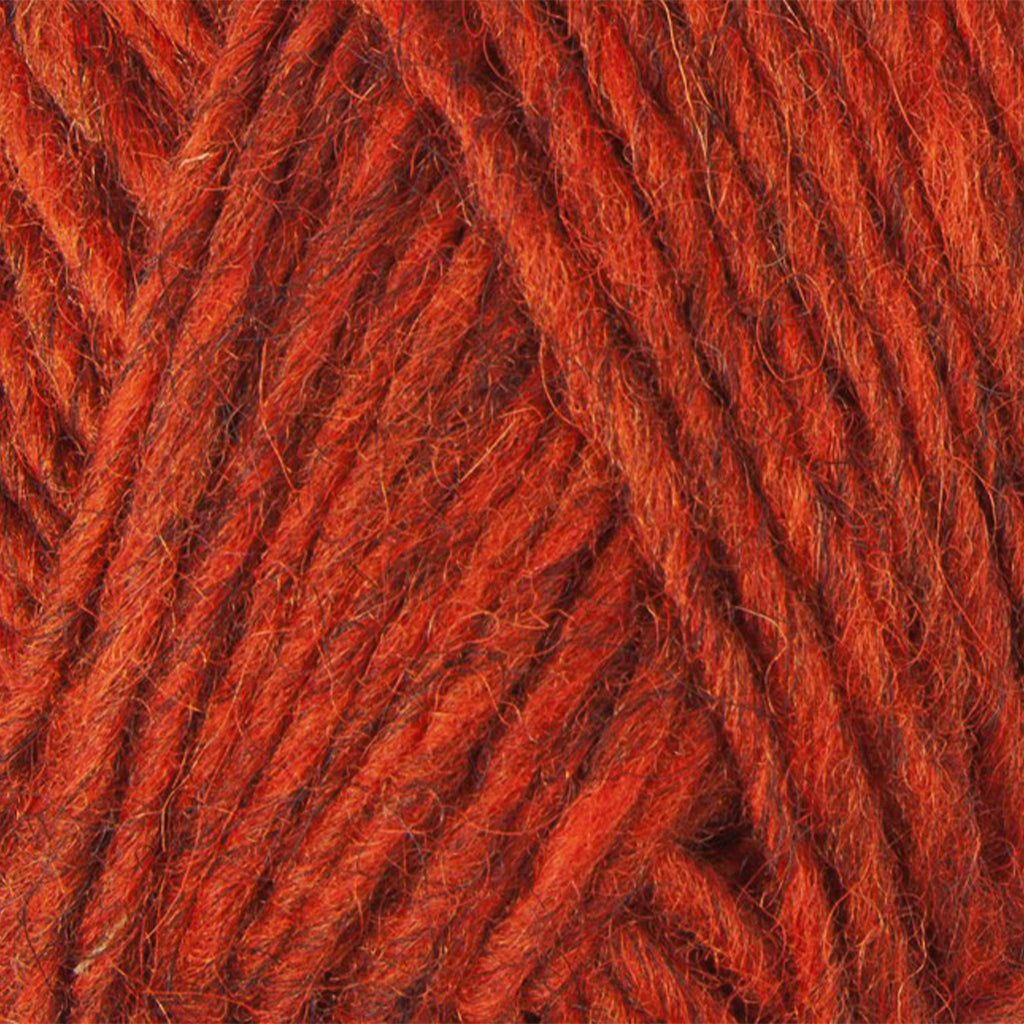 Burnt Orange 1236, a vibrant red orange heathered skein of Lopi's Álafosslopi, a bulky wool yarn.