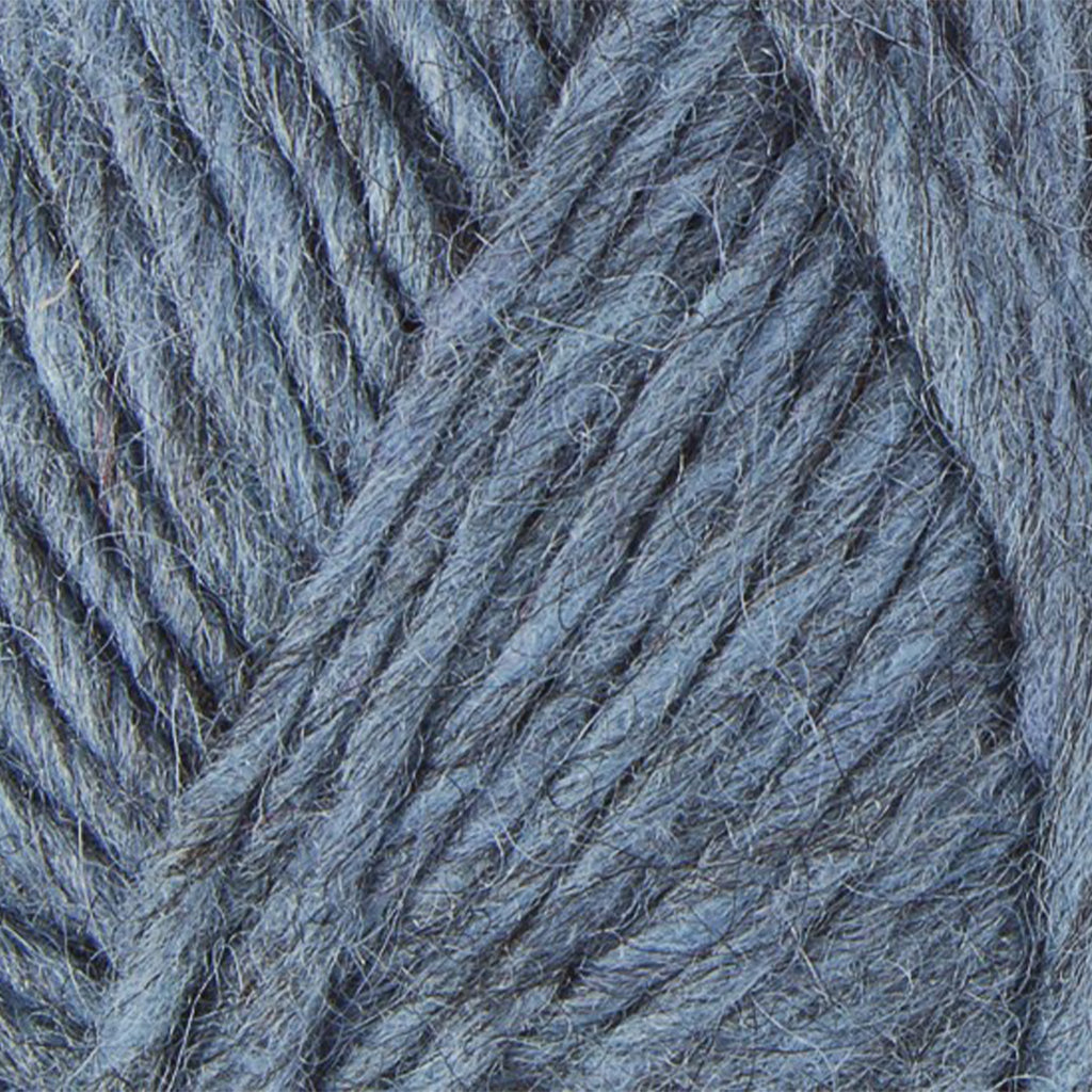 Light Indigo 9958, a light blue and black heathered skein of Lopi's Álafosslopi, a bulky wool yarn.