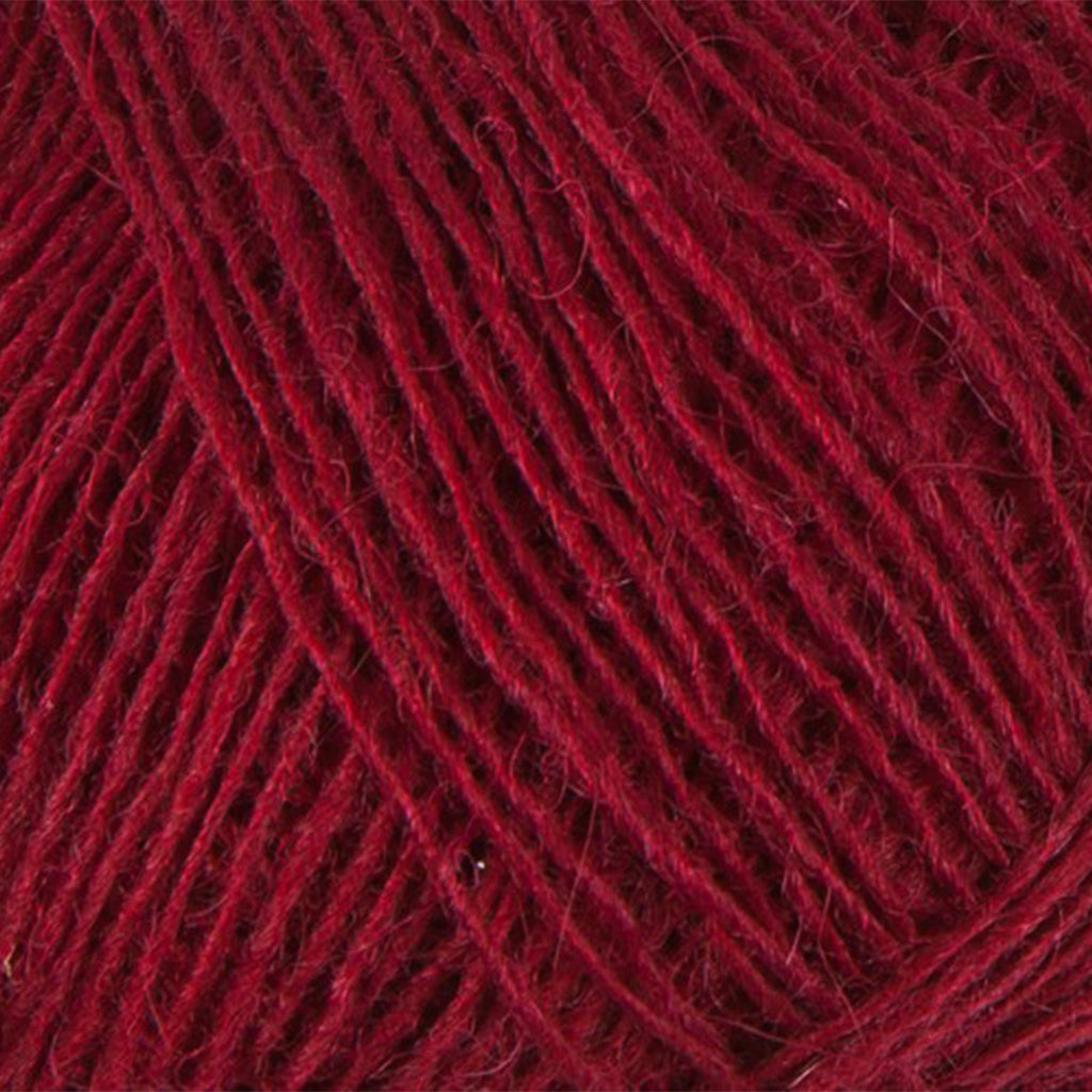 Brick 9165, a vibrant dark red skein of Lopi's Einband Icelandic wool lace yarn.