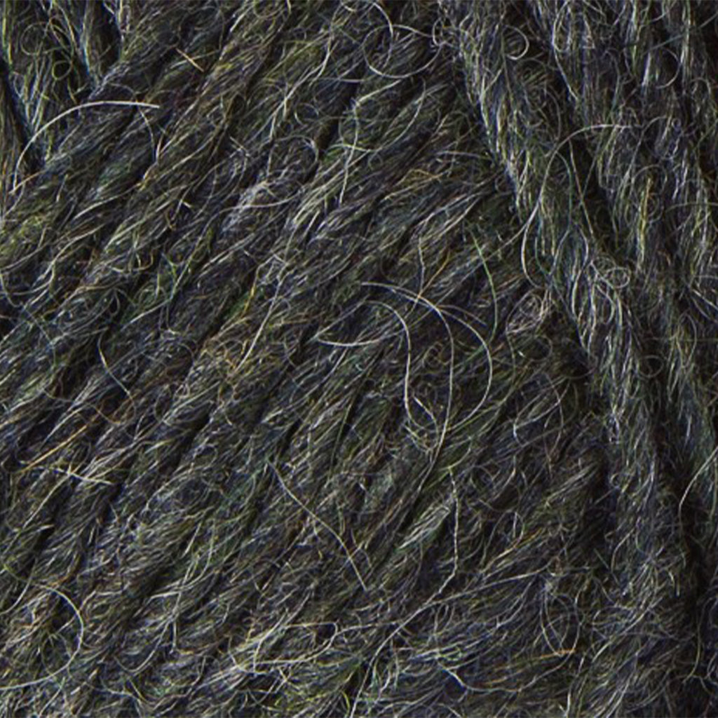 Rough Sea 1415, a dark heathered navy, green, and white skein of Léttlopi Icelandic wool yarn.