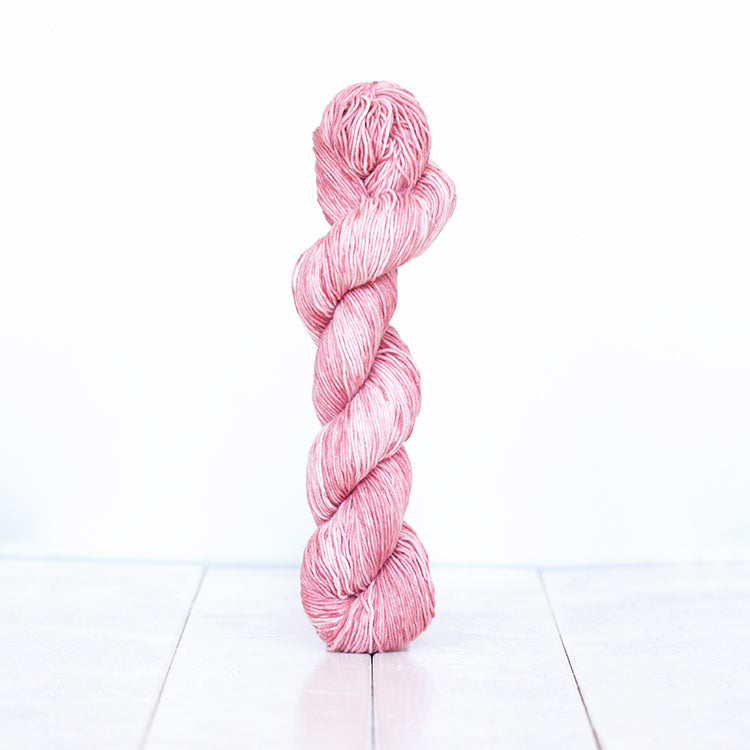 1205, a rose pink skein of Urth Yarn's hand-dyed Monokrom Cotton DK weight yarn.