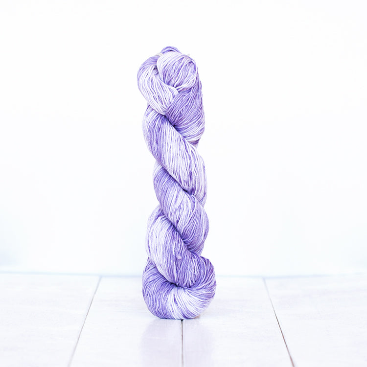 1206, a lavender purple skein of Urth Yarn's hand-dyed Monokrom Cotton DK weight yarn.