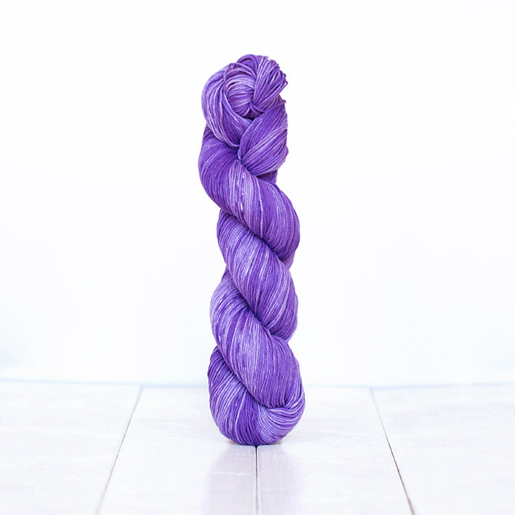 1214, a vibrant violet skein of Urth Yarn's hand-dyed Monokrom Cotton DK weight yarn.
