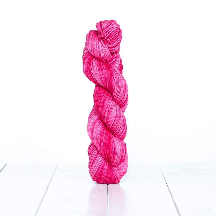 1217, a electric candy pink skein of Urth Yarn's hand-dyed Monokrom Cotton DK weight yarn.